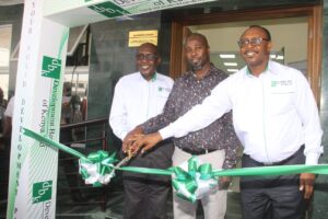 Development Bank of Kenya Chairman Ndungu Githinji (left) and the bank’s Chief Executive Officer and Managing Director Johnson Kiniti (right) are joined by Mombasa County government County Executive Committee Member  for Finance and Economics Evans Owanda in cutting ribbon tape to officially open their new branch in Moi avenue , Mombasa on Thursday